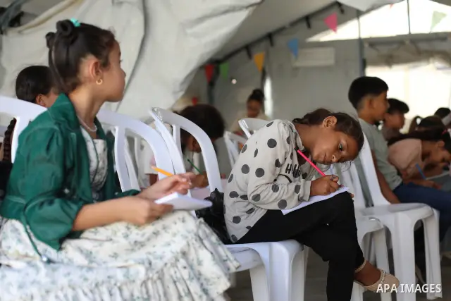 Palestinian students attend a lesson inside a tent in al-Bureij camp in the central Gaza Strip on September 26, 2026, as the new academic year resumes. Classes are being held amid widespread damage to schools and shortag...