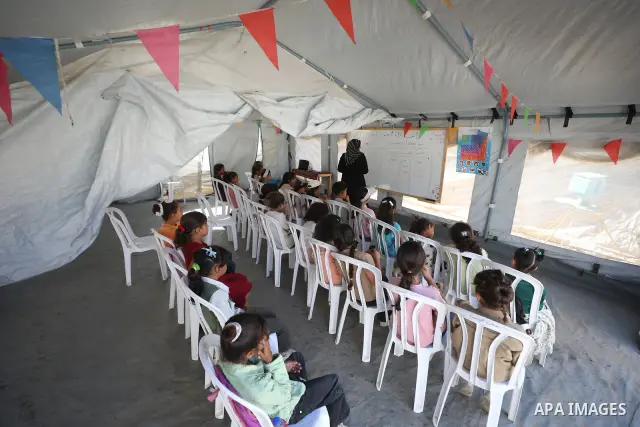 Palestinian students attend a lesson inside a tent in al-Bureij camp in the central Gaza Strip on September 26, 2026, as the new academic year resumes. Classes are being held amid widespread damage to schools and shortag...