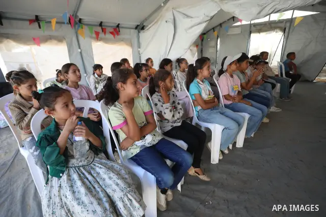Palestinian students attend a lesson inside a tent in al-Bureij camp in the central Gaza Strip on September 26, 2026, as the new academic year resumes. Classes are being held amid widespread damage to schools and shortag...